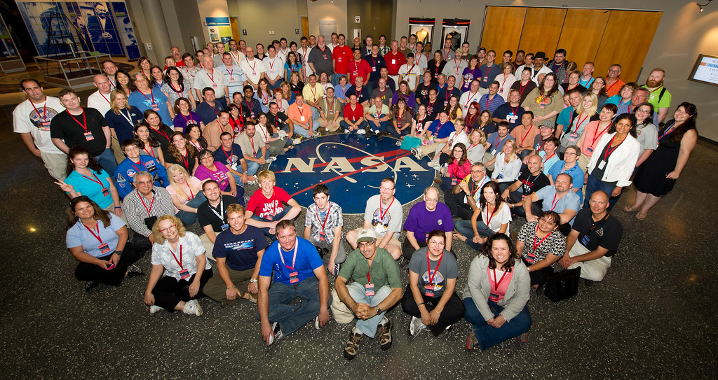 A large group of NASA Social attendees posed around the NASA insignia on the floor at Kennedy Space Center before the GRAIL launch in September 2011